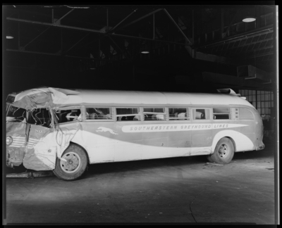 Southeastern Greyhound Lines; interior of garage; wrecked                             (damaged) bus number 803 (no. 803) (Columbia), side view