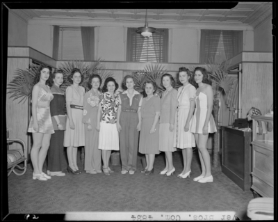 Meyers Brothers (278 West Main and Mill Streets); interior, two                             women in bathing suites standing with a group of women; group                             portrait
