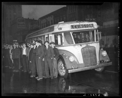 Southeastern Greyhound Lines (bus); group of men standing next to                             a bus parked by the curb