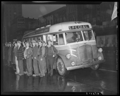 Southeastern Greyhound Lines (bus); group of men standing next to                             a bus parked by the curb