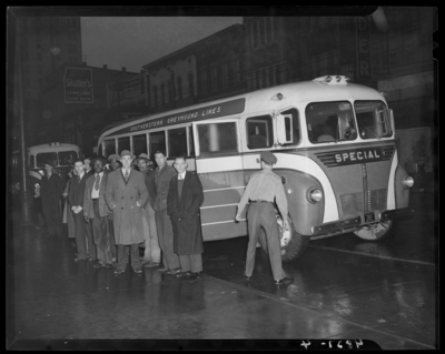 Southeastern Greyhound Lines (bus); group of men standing next to                             a bus parked by the curb