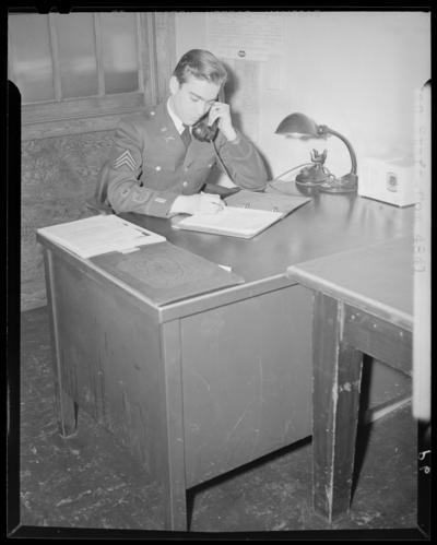 Kentuckian Staff & Press Room, (1942 Kentuckian)                             (University of Kentucky); McVey Hall, basement; student in uniform                             sitting at a desk
