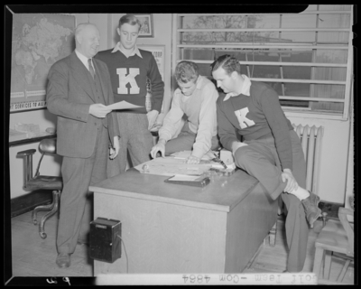 Golf Team, (1942 Kentuckian) (University of Kentucky); members                             gathered around a desk