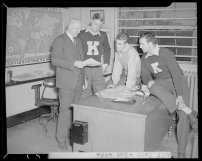 Golf Team, (1942 Kentuckian) (University of Kentucky); members                             gathered around a desk