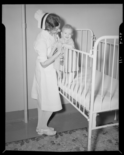 Kentucky Crippled Children’s Commission, Good Samaritan Hospital;                             nurse standing next to a baby in a crib