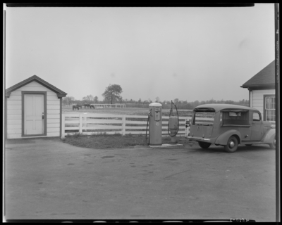 Dixiana Farm, (Russell Cave Road); exterior, horses in pasture                             seen in the distance; car parked next to a gas pump