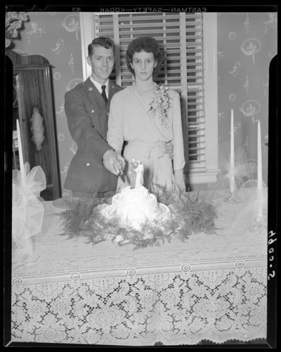 Mr. & Mrs. Perkins; wedding; portrait of wedding couple                             ready to cut their cake; Lowell Perkins (groom); Ann Kaninberg                             (bride)