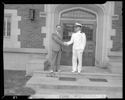 Moorhead College; building, exterior steps; two men shaking                             hands, one of the men wearing a naval (navy) uniform