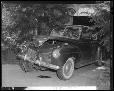 J. Van Hooser; wrecked (damaged) car parked in driveway; front                             and driver's side view; 1942 Fayette County Kentucky license plate                             number M7855 (no. M7855); photographs requested by Aetna                             Casualty