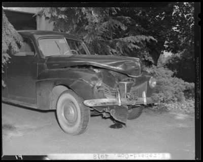 J. Van Hooser; wrecked (damaged) car parked in driveway; front                             and passenger's side view; 1942 Fayette County Kentucky license                             plate number M7855 (no. M7855); photographs requested by Aetna                             Casualty