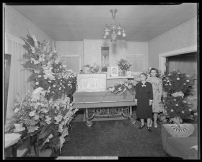 Mrs. Clay Adams; corpse, open casket; two women standing next to                             open casket