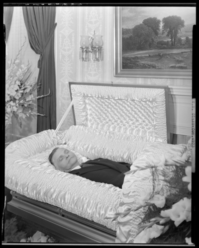 E.M. Glass; corpse, open casket