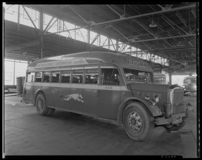 Southeastern Greyhound Lines (bus); wrecked (damaged) bus parked                             inside a service garage (repair); bus number 440 (no. 440);                             passenger's side view; destination sign reads                             