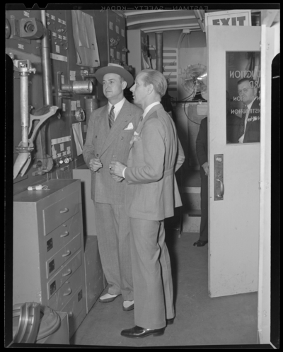 War Production Board; production studio, interior; Governor Keene                             Johnson standing with another man next to equipment