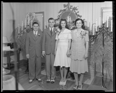 Mr. & Mrs. Robert Walker; wedding; bride and groom                             standing besides another man and woman in front of a decorated                             fireplace
