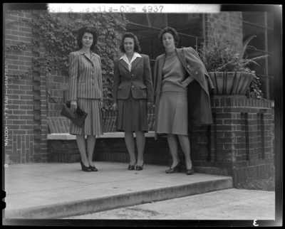 Loom & Needle (clothing retailer); three women standing                             in front of brick building