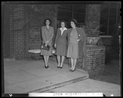 Loom & Needle (clothing retailer); three women standing                             in front of brick building