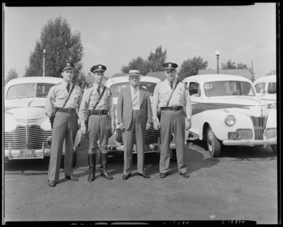 Kentucky State Highway Patrol, (1942 Kentuckian) (University of                             Kentucky); three patrolman (police officers) and another man standing in                             front of police cars