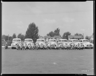 Kentucky State Highway Patrol, (1942 Kentuckian) (University of                             Kentucky); group of patrolman (police officers) squatting in front of a                             row of police cars