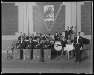 Bill Cross; orchestra; interior of unidentified building;                             orchestra members on stage