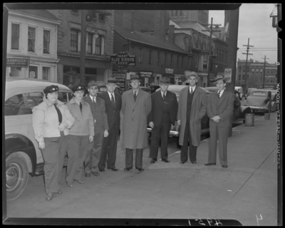Lexington Yellow Cab, 150 North Limestone; group for first women                             drivers; two women drivers in uniform standing with a group of men in                             front of cab cars; West Short Street; Jim Curry (Restaurant), 140 West                             Short; American Dry Cleaners, 130 West Short; Lexington Typewriter                             Exchange, 144 West Short; L.H. Lewis & Company, 150 West                             Short