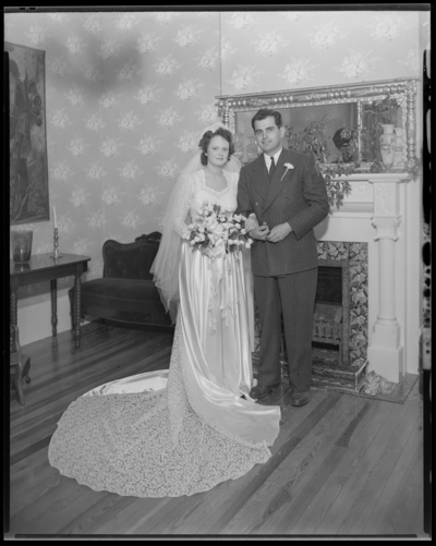Robinson Wedding (two weddings); West Maple, Nicholasville);                             portrait book; bride and groom standing in front of a                             fireplace