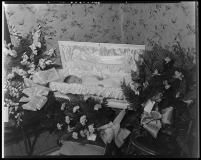 Mrs. Beatrice Wickline; baby corpse; open casket surrounded by                             flowers