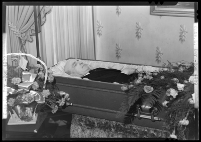 Chas. L. Day; corpse; open casket surrounded by                             flowers