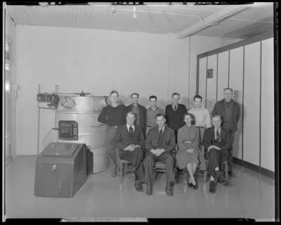 Howard Furnace Company; group gathered in room next to                             furnace