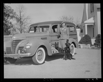 Mrs. Royce Martin; woman standing next to car with                             dogs