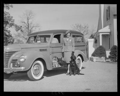 Mrs. Royce Martin; woman standing next to car with                             dogs