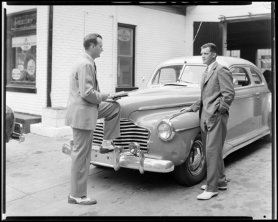 Lexington General Tire Company, 254 East Main; two men talking                             next to car