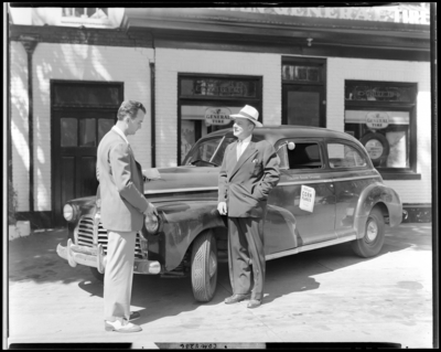 Lexington General Tire Company, 254 East Main; two men standing                             next to car