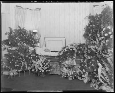 Delbut White; corpse; open casket surrounded by                             flowers