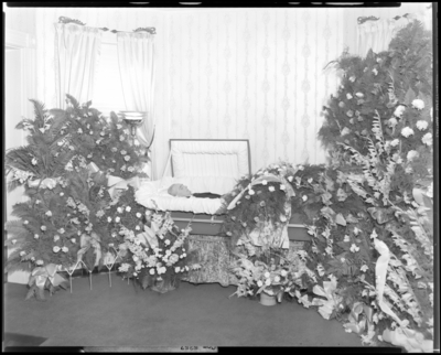 Delbut White; corpse; open casket surrounded by                             flowers