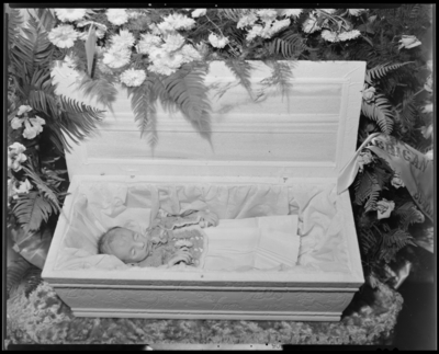 Jimmy Newman; baby corpse; open casket surrounded by                             flowers