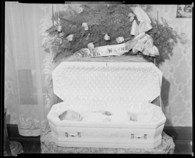 Barry Wayne; baby corpse; open casket surrounded by                             flowers