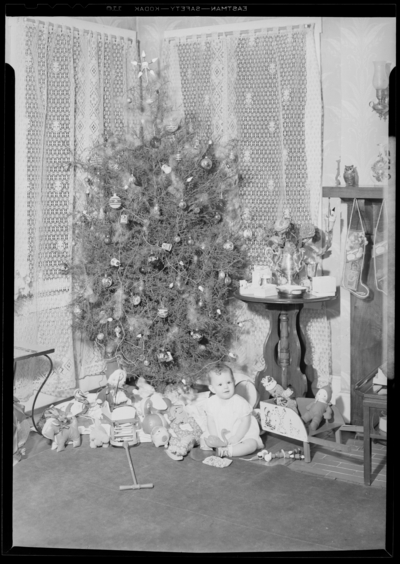 Mrs. Howard Wells; inteior; baby sitting next to Christmas                             tree