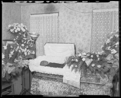 Daniel Jackson; corpse; open casket surrounded by                             flowers