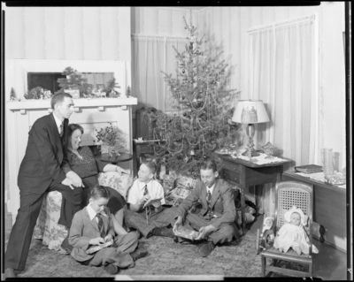 Mrs. W. R. Pickett; children opening presents beneath Christmas                             tree while parents watch