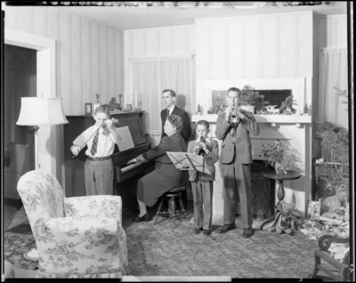 Mrs. W. R. Pickett; mother and children playing musical                             instruments while father watches