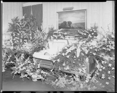 Mrs. H.M. Milton; corpse; open casket surrounded by                             flowers