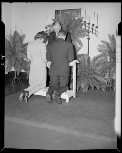 J. Davis; wedding; church interior; bride and groom kneeling                             before minister