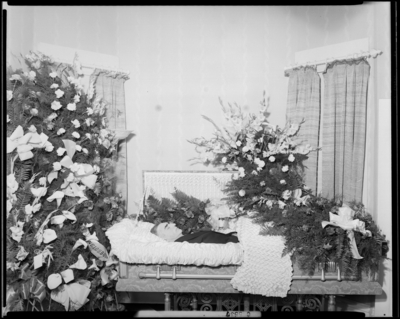 Theodore Rayburn; corpse; open casket surrounded by                             flowers