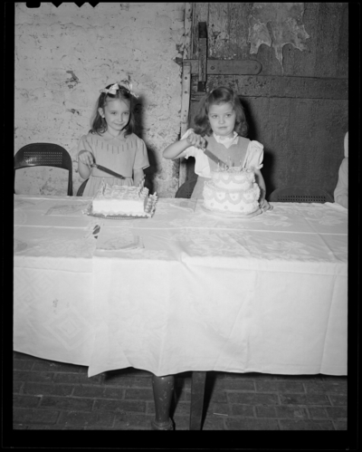 Bobby Jean Beagle; birthday party, age 6; Castlewood Barn;                             interior; two girls cutting their birthday cakes