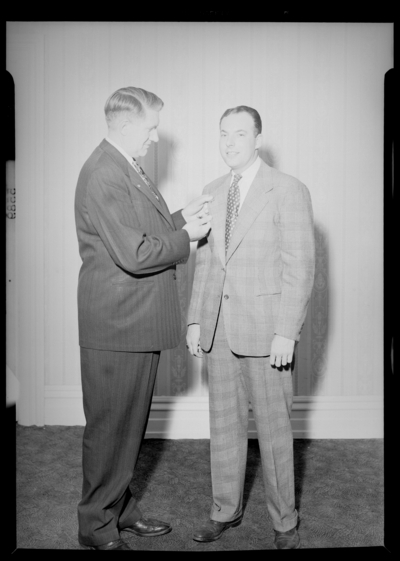 National Life & Accident Insurance Company; Phoenix                             Hotel; interior; Luncheon; two men standing together; man placing a pin                             on the other man's lapel