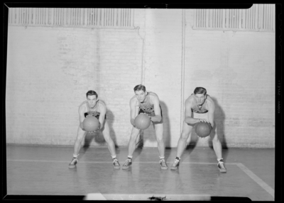 Georgetown College; Basketball; gym (gymnasium); interior; three                             players holding basketballs in shooting position