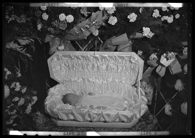 John Jr., Albert Henry; baby corpse; open casket surrounded by                             flowers