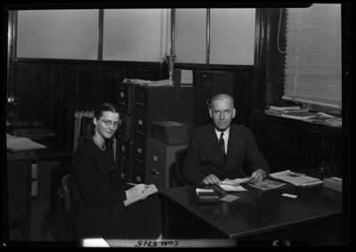 Georgetown College; Belle of the Blue; interior; office; man                             sitting at desk while secretary takes dictation