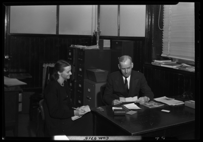 Georgetown College; Belle of the Blue; interior; office; man                             sitting at desk while secretary takes dictation